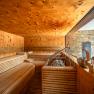 Interior view of a modern sauna with wooden benches and a large window.