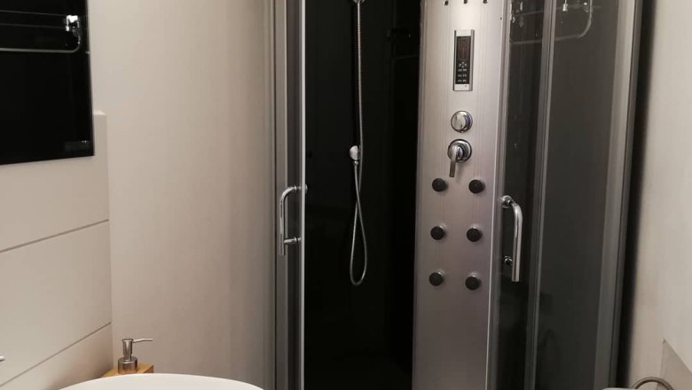 Modern bathroom with shower cubicle, washbasin and toilet.