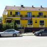 Yellow building with the inscription 'Gasthof', two parked cars in front of it.