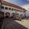 Inner courtyard of a historic building with arcades and seating.