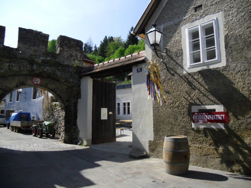 Entrance to a traditional wine tavern with archway and sign.
