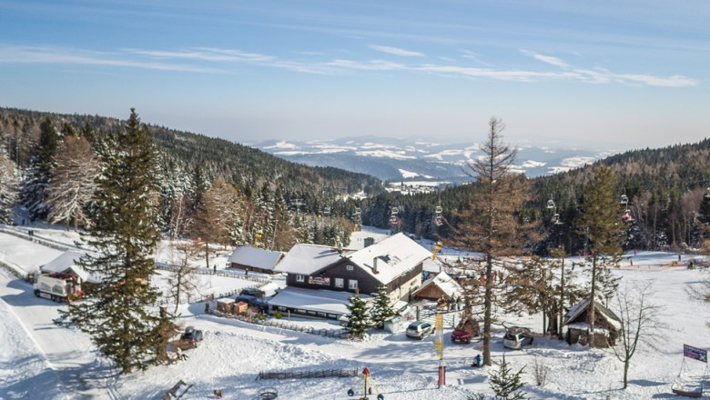 Winter landscape with mountain inn and ski lift in Mönichkirchen.
