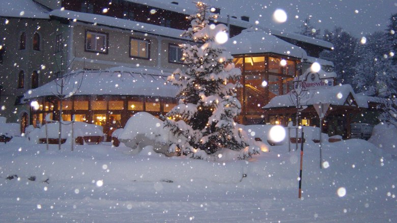 Snow-covered building with Christmas tree and lights, Ramswirt sign visible.