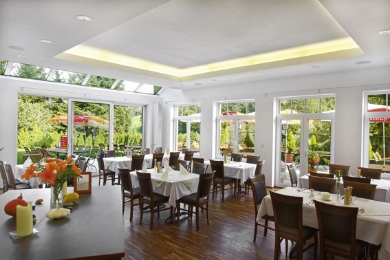 Interior view of a bright restaurant with large windows and laid tables.