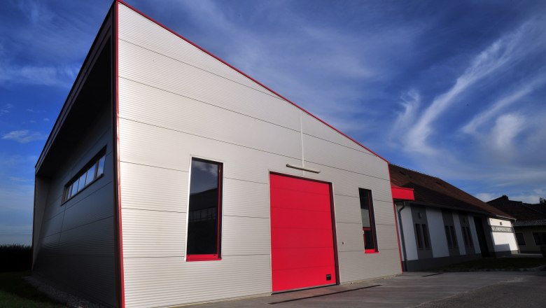 Modern building with red gate and blue sky in the background.