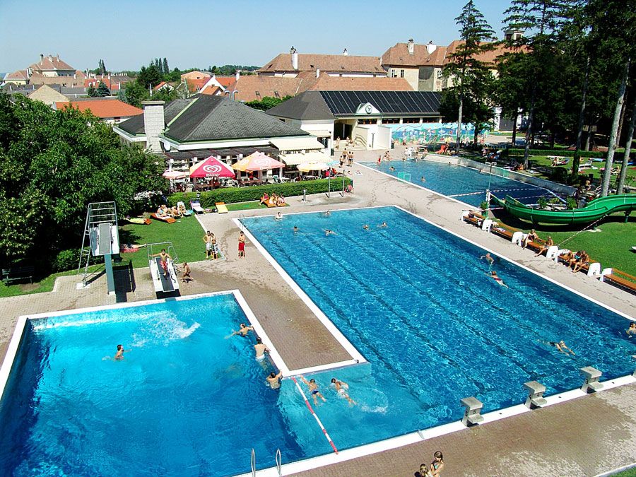 Aerial view of an outdoor swimming pool with several pools and a slide.