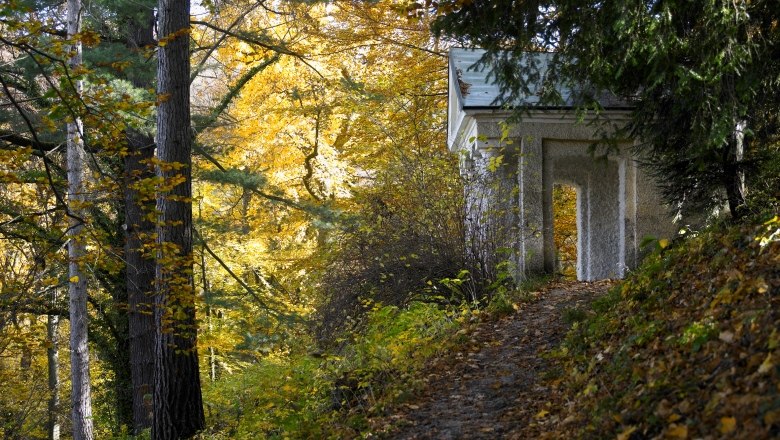 Autumn scene in Lilienfeld Abbey Park with foliage and a small building.