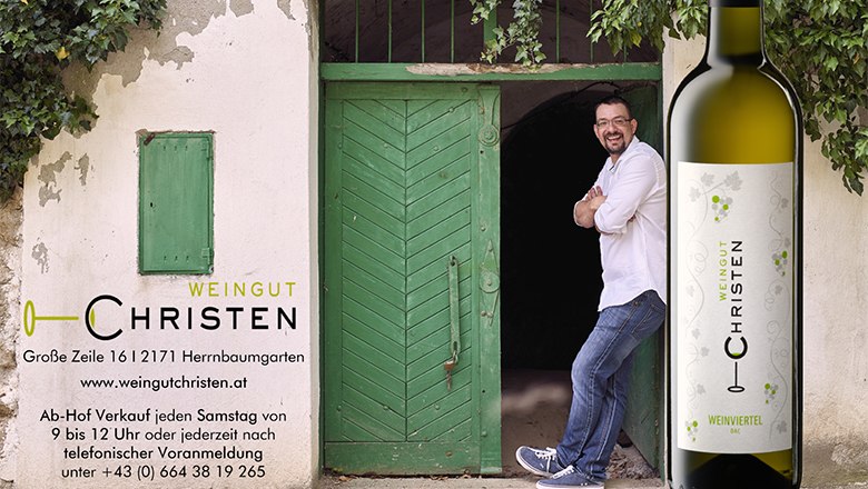 A man leans against a green door next to a bottle of wine with the label 'Weingut Christen'.