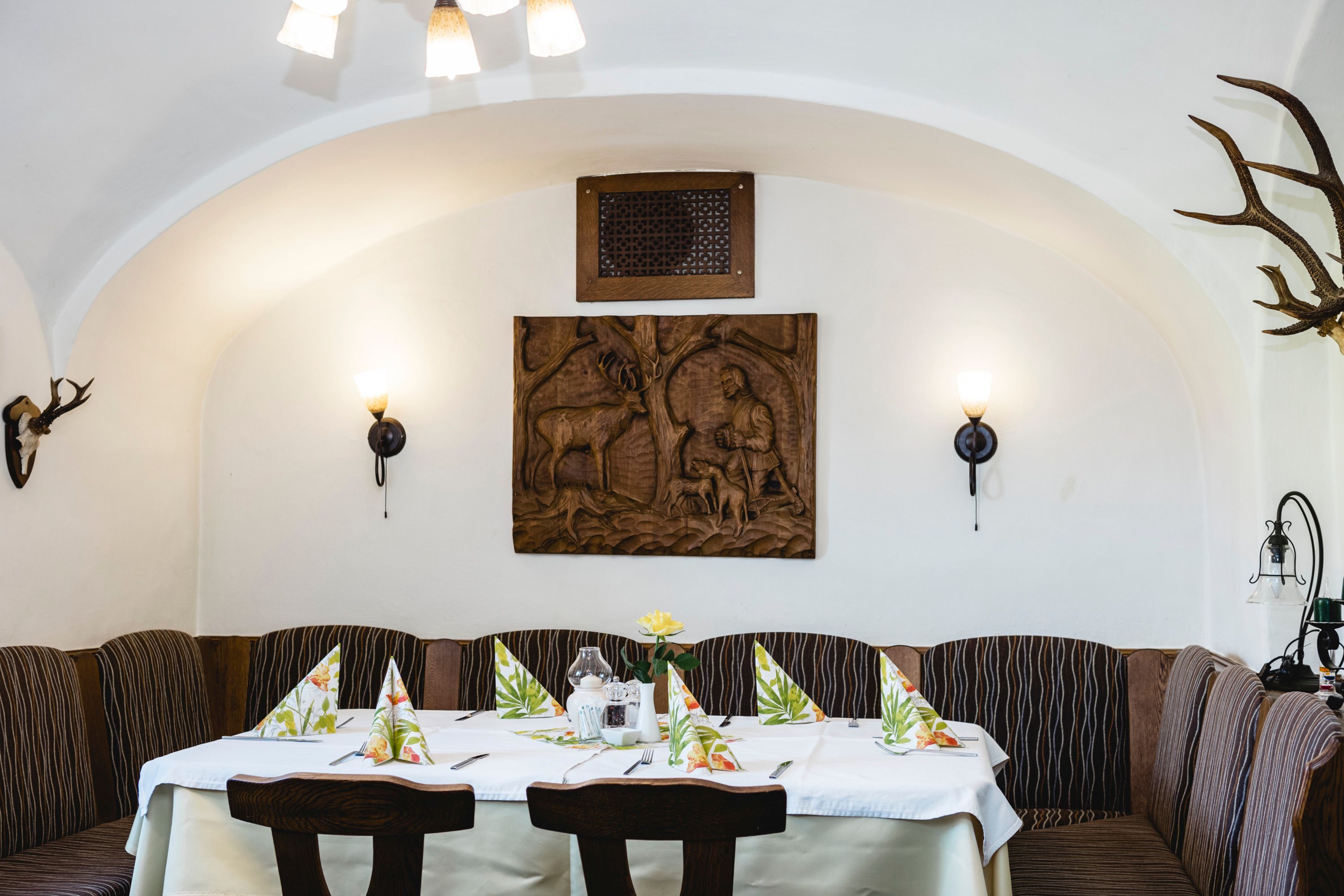 Cozy guest room with wood paneling and hunting motifs on the wall.