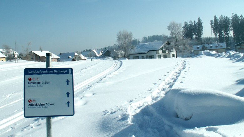 Winter landscape with cross-country ski trail and signpost in Bärnkopf.