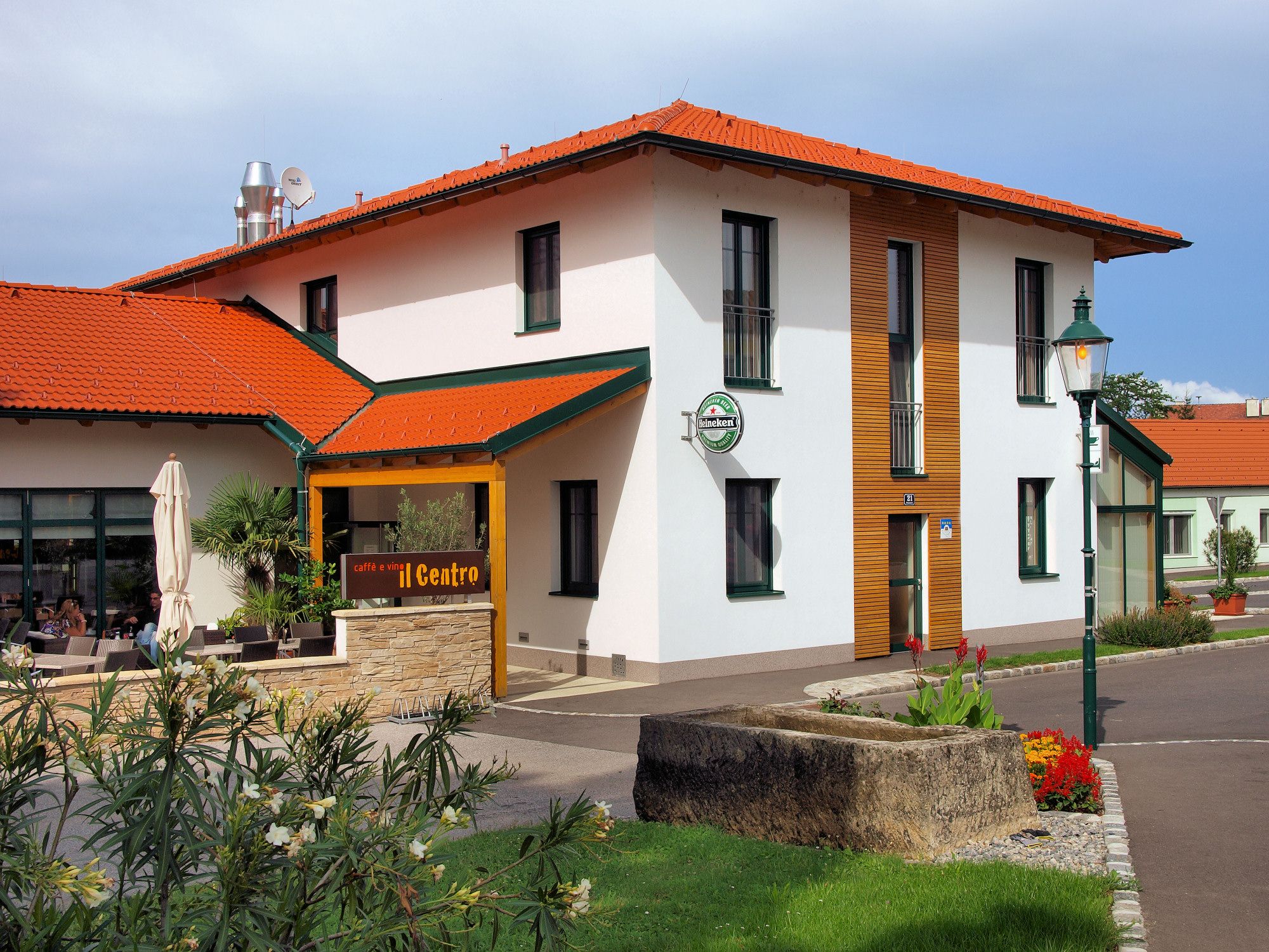 Exterior view of a building with a red roof and terrace, labeled 'caffè e vini Centro'.