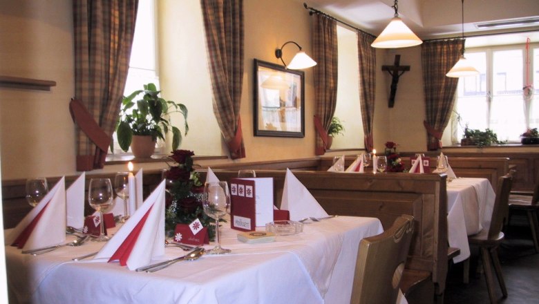 Cozy restaurant with laid tables, wooden furniture and checkered curtains.