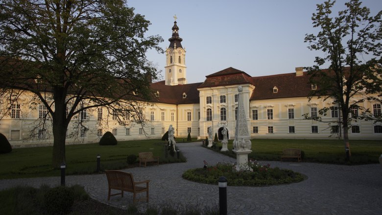Altenburg Abbey with garden and sculptures in the foreground.