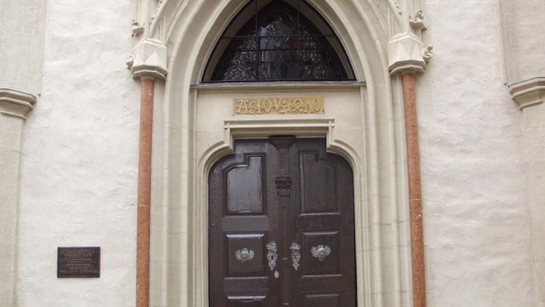 Entrance to the B&uuml;rgerspitalskirche with Gothic portal and wooden door.