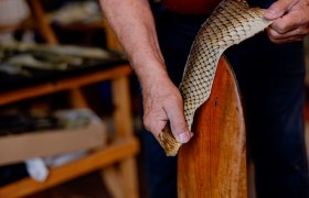Close-up of hands working on a piece of fish leather.