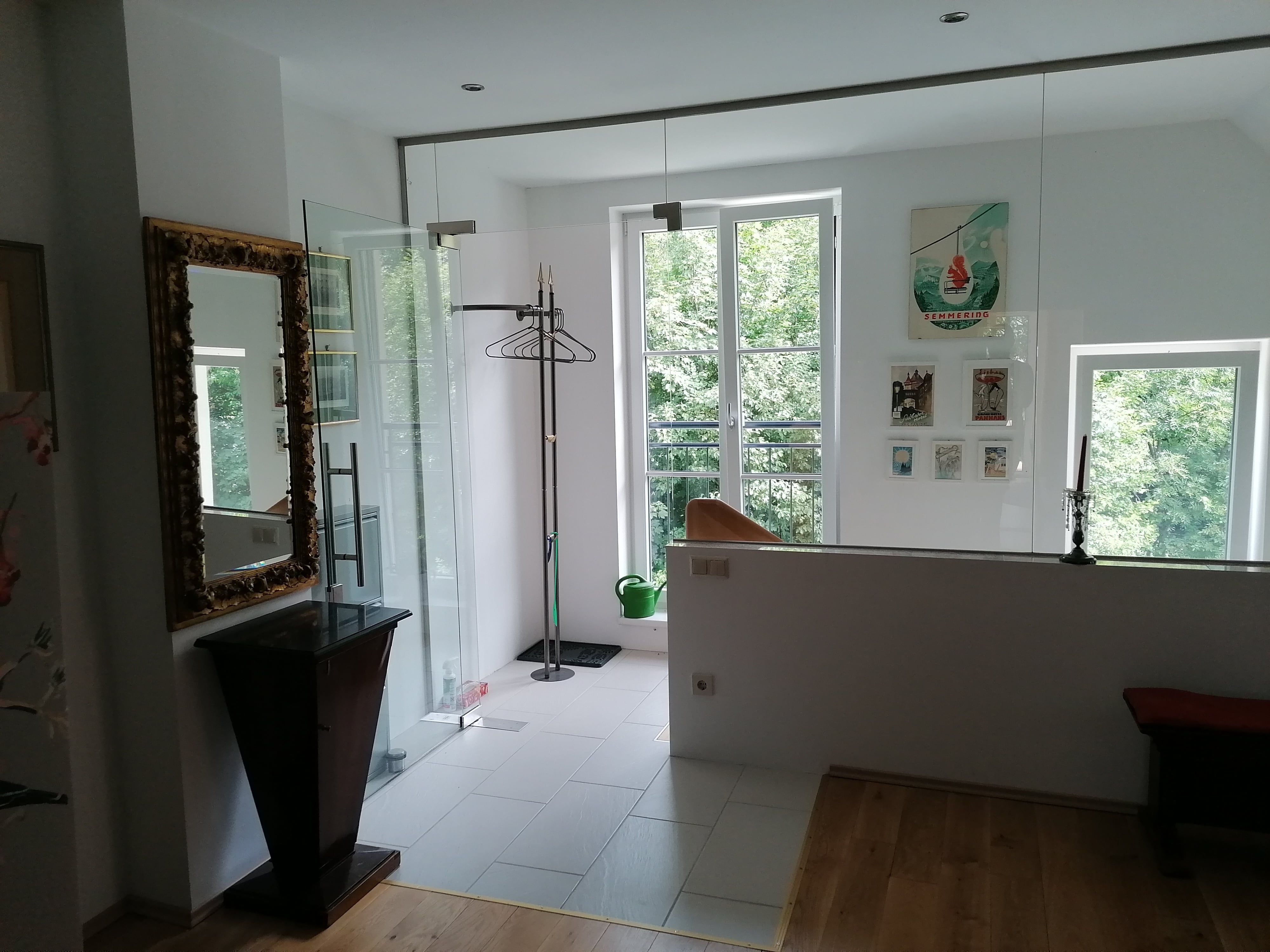 Entrance area of a vacation apartment with mirror, clothes rack and pictures on the wall.