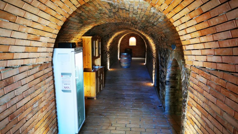 Brick vaulted cellar with wooden cupboards and wine barrels.