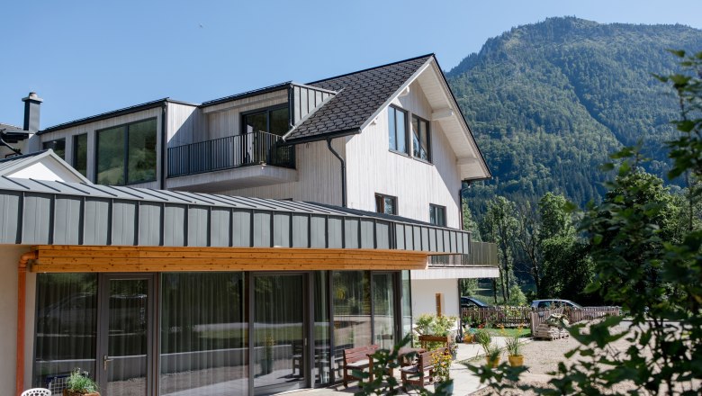 Modern house with a mountain in the background on a sunny day.