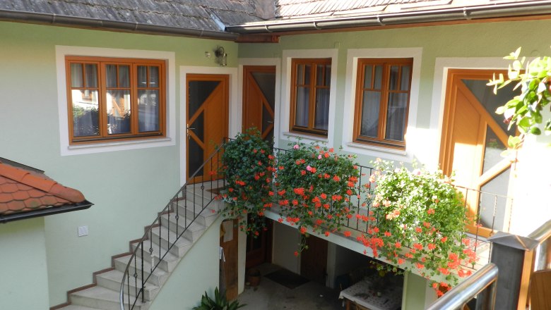 Courtyard Winzerhof Mörtinger, © Familie Mörtinger Inner courtyard with stairs, flowers and table.
