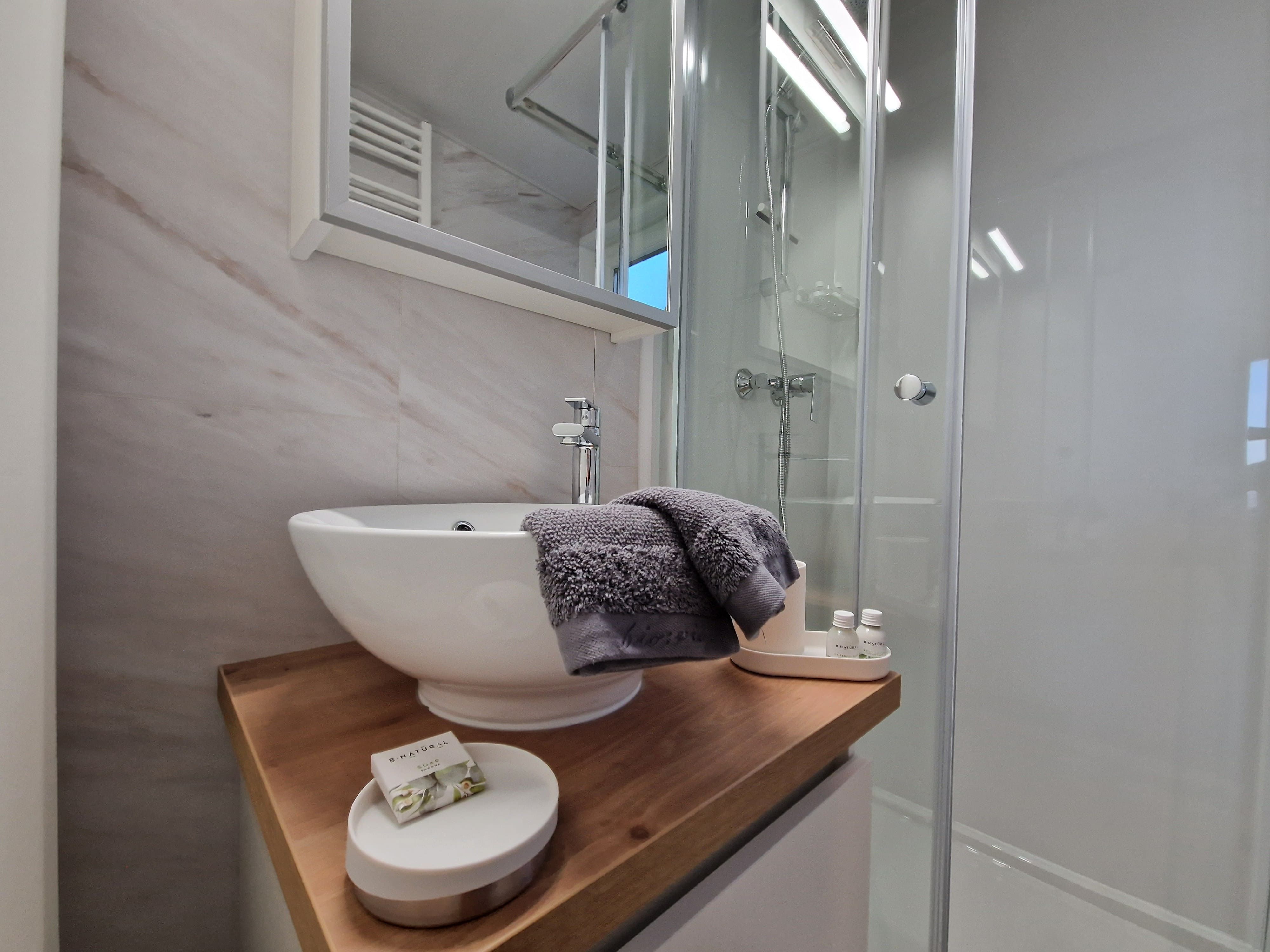 Modern bathroom with washbasin, mirror and shower.