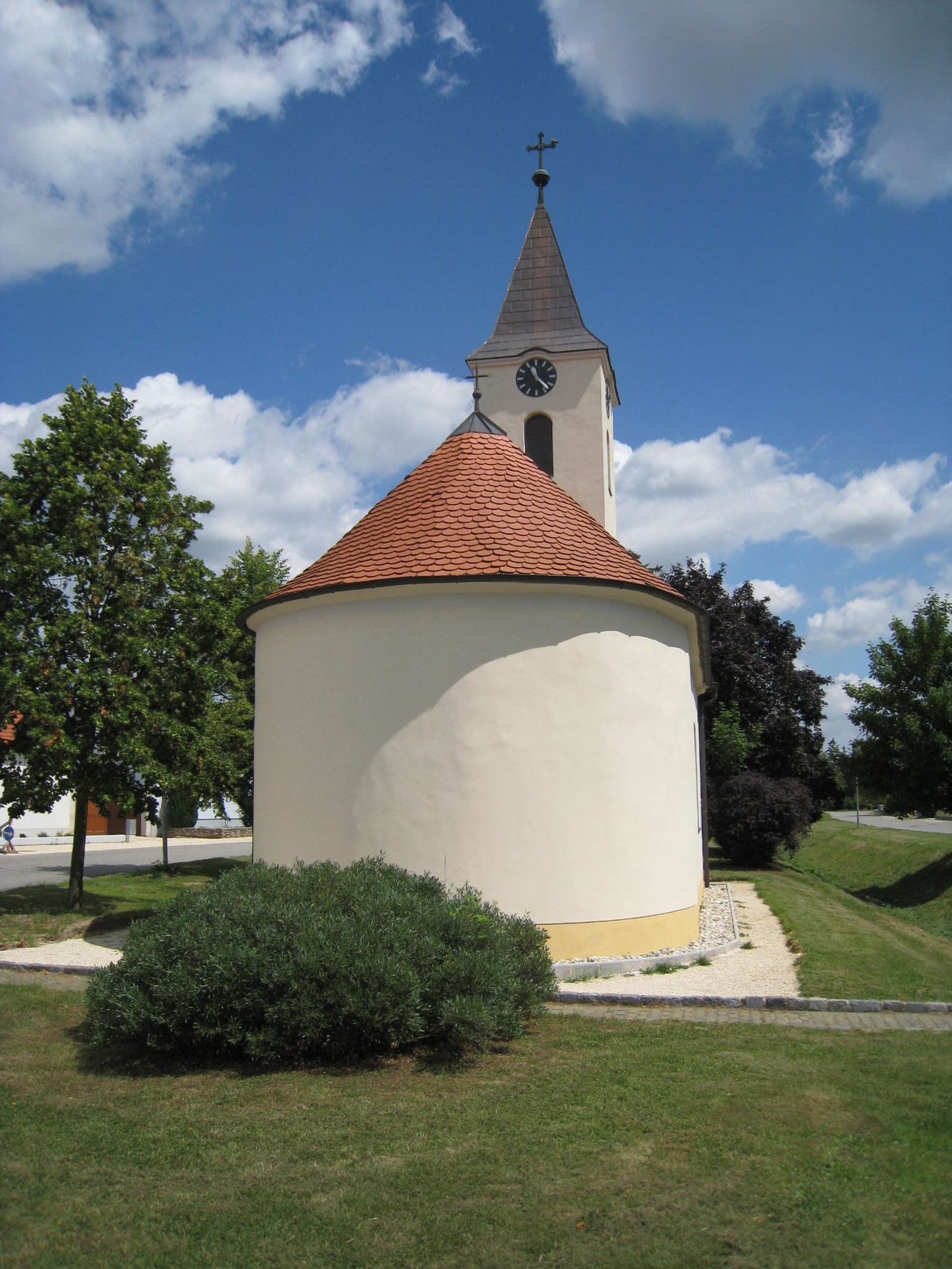 Chapel of St. Barbara with round roof and tower against a blue sky.