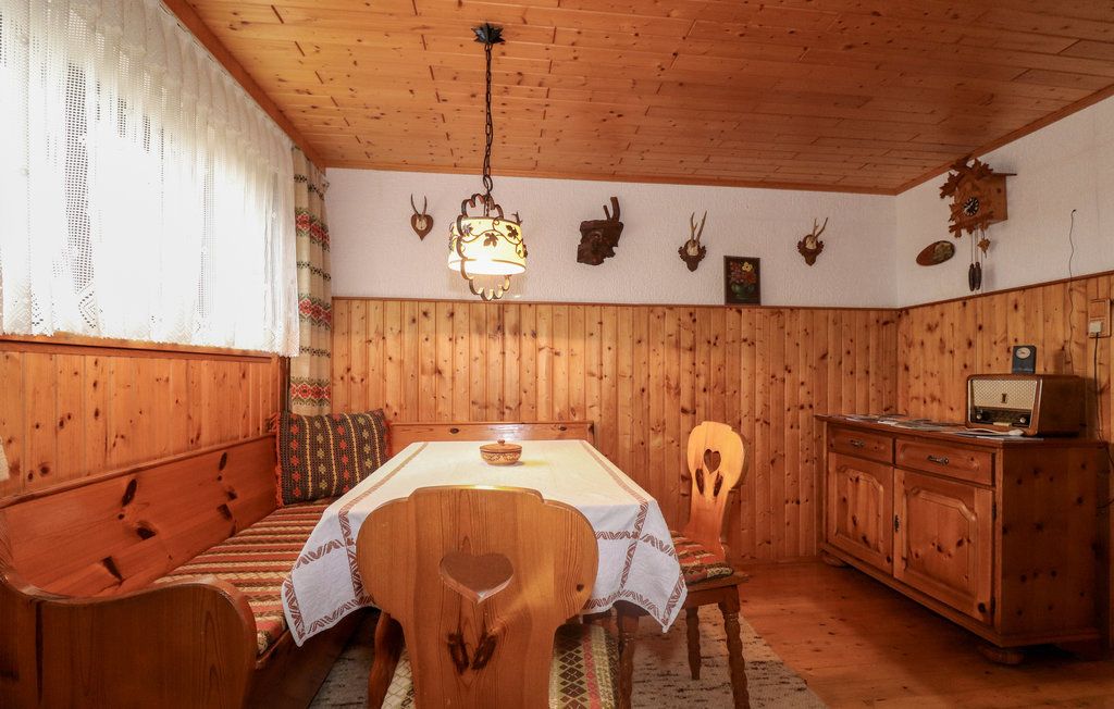 Cozy cellar room with wooden furniture, corner bench, table, radio and hunting trophies on the wall.
