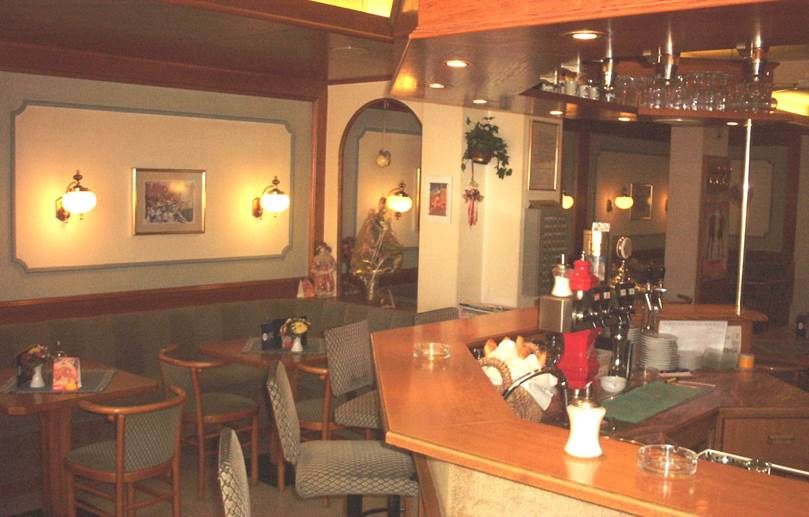 Interior view of a cozy café with wooden counters and seating areas.
