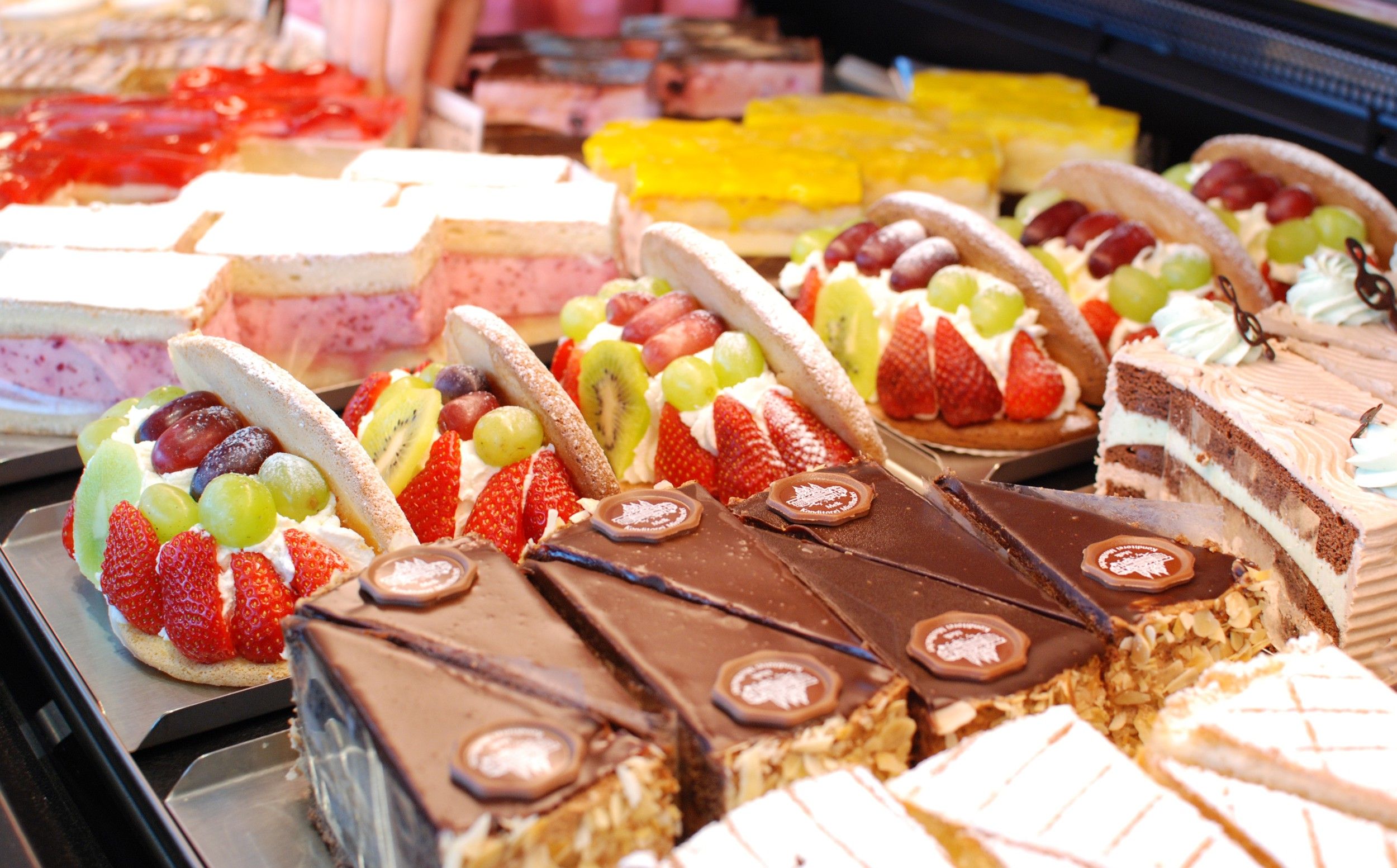Display case with various cakes and tarts in a patisserie.
