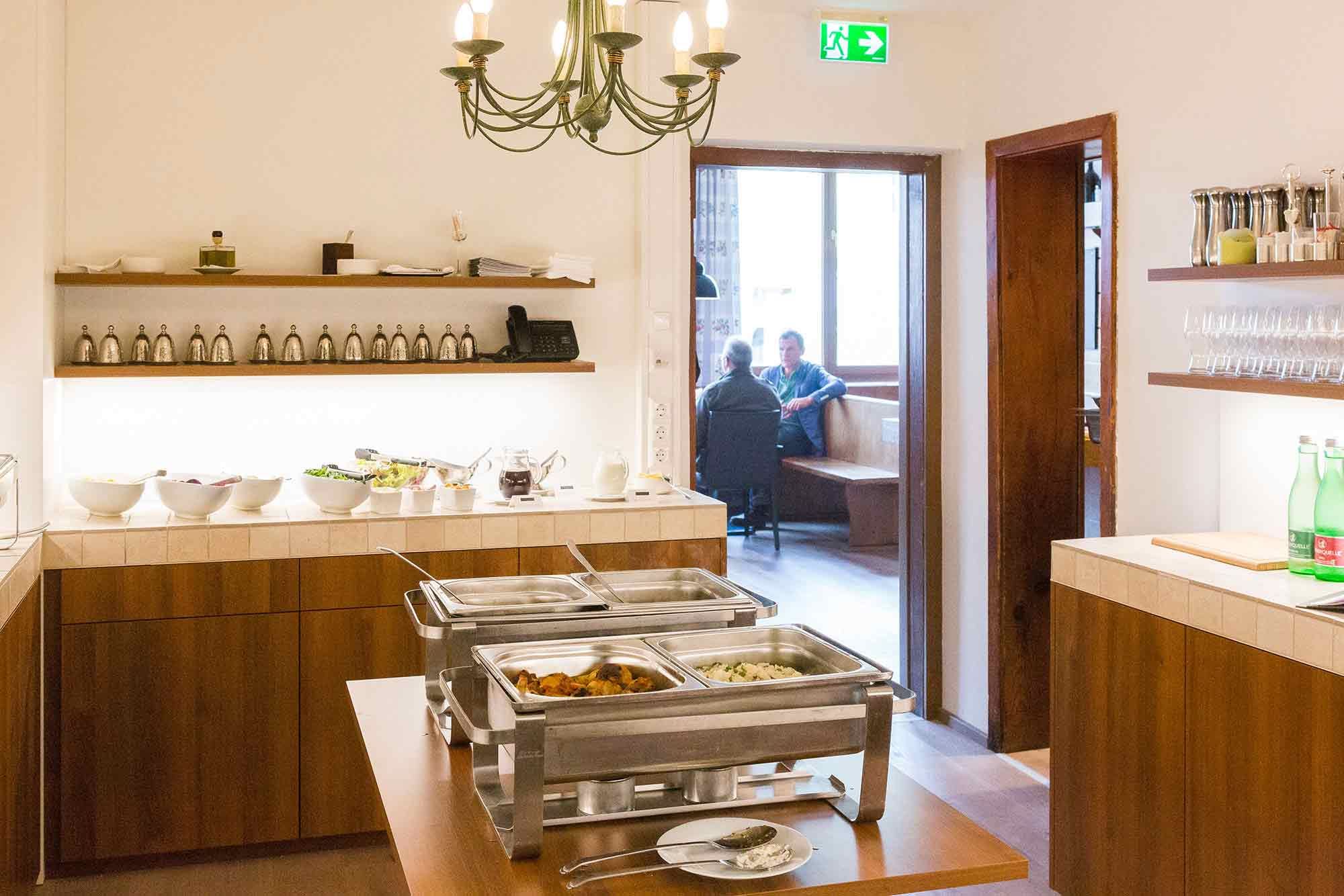 Buffet room with food and view into an adjoining room with two people.