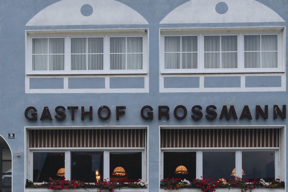 Facade of the Grossmann inn with windows and flower boxes.