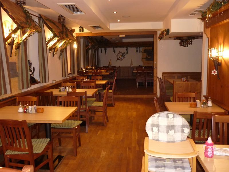 Interior view of a rustic restaurant with wooden furniture and decorations.