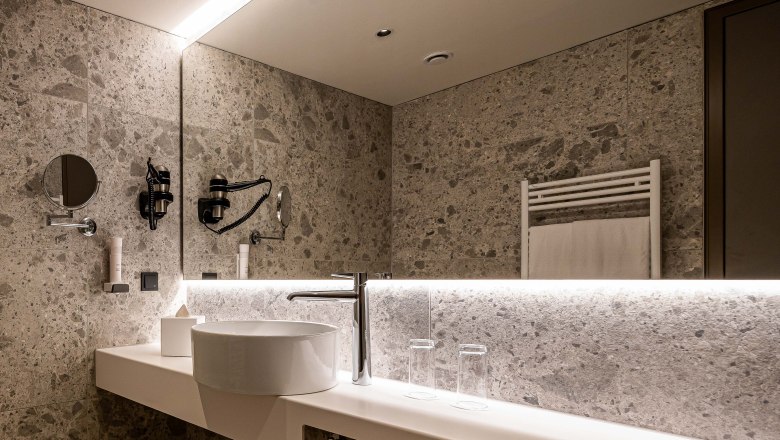 Modern bathroom with washbasin, mirror and towel rail.