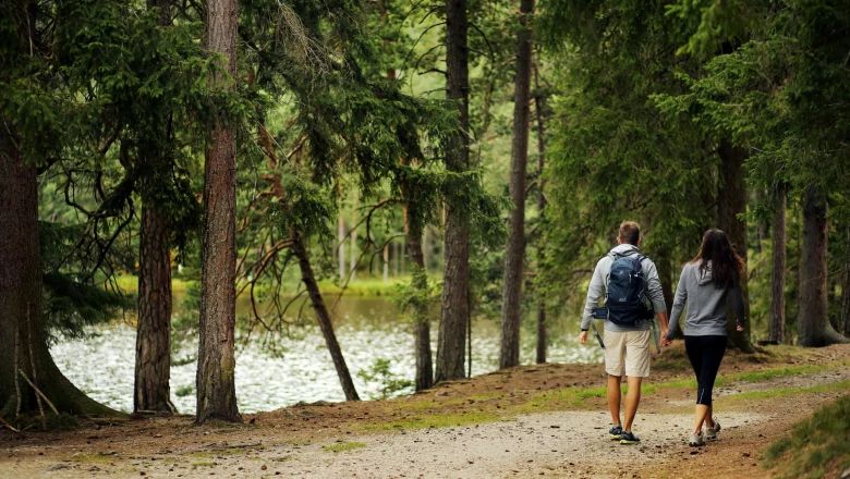 A couple walks along a forest path by Lake Edlesberg.