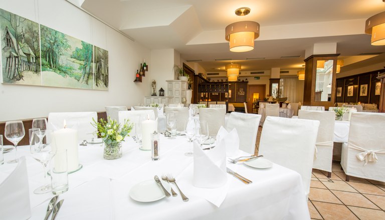 The winter garden with a laid table and white chairs.
