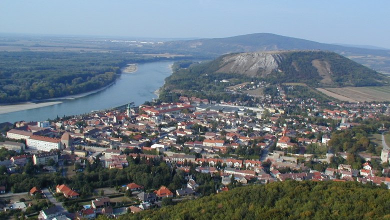 Panoramic view of a city with a river and hills in the background.