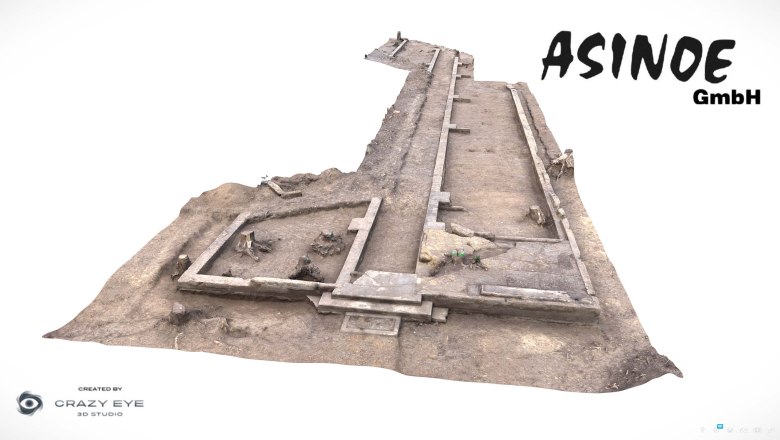 3D model of an archaeological excavation site with rectangular structures and earth surface.
