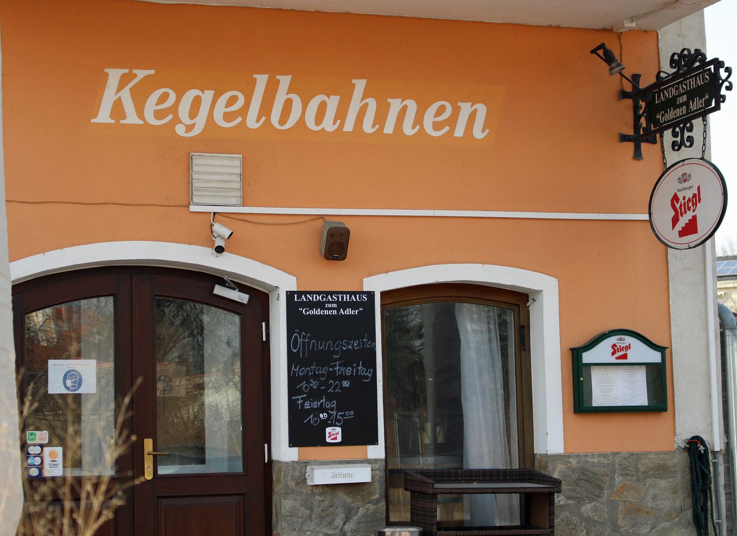 Entrance to a country inn with the inscription 'Kegelbahnen' and a Stiegl beer sign.