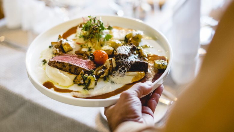 Gourmet dish with venison, cauliflower cream and walnut gnocchi on a plate.