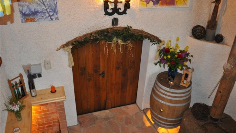 Rustic wine cellar decoration with wooden door, flowers and wine barrel.