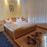 Comfortable guest room with double bed, colorful carpets and wooden furniture.