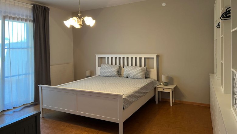 Bedroom with white bed, bedside table and closet.