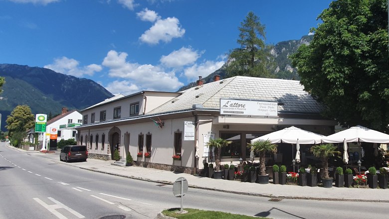 Street scene with L'attore restaurant and mountains in the background.