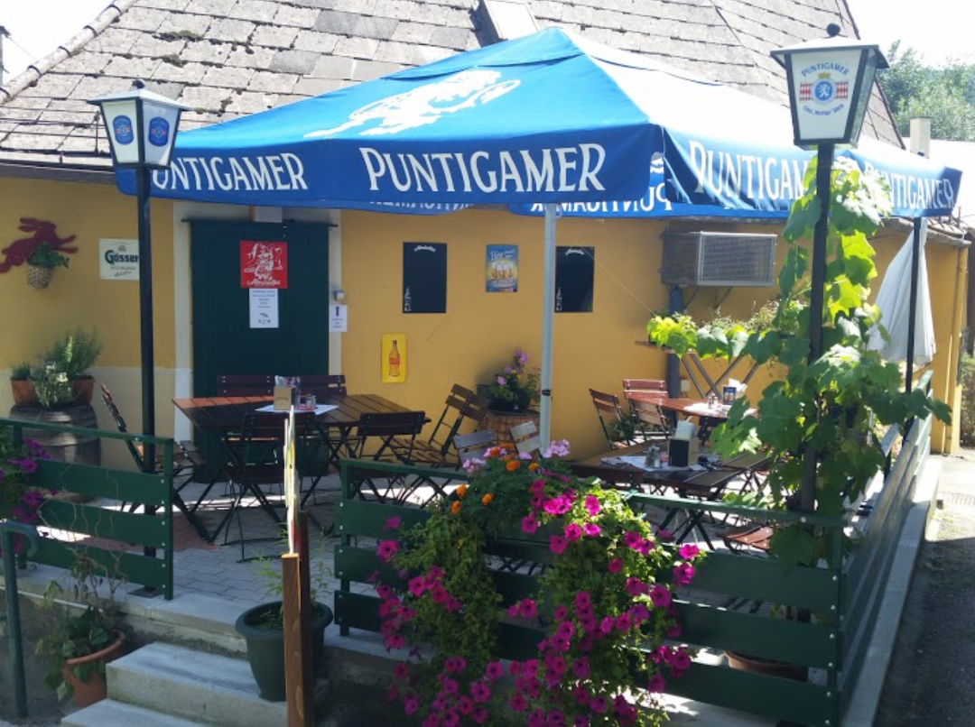 Outdoor area of a pub with blue parasols and flowers.