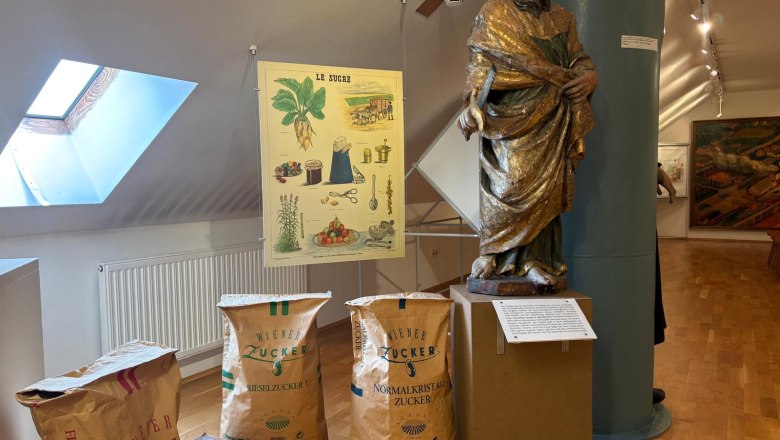 Exhibition in the Sugar Museum with statue, sugar sacks and poster.