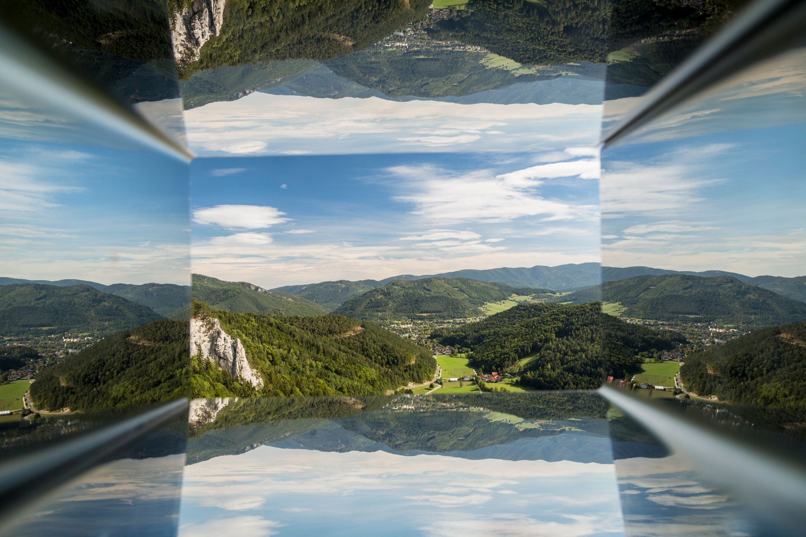 Reflection of a mountain landscape with blue sky and clouds.