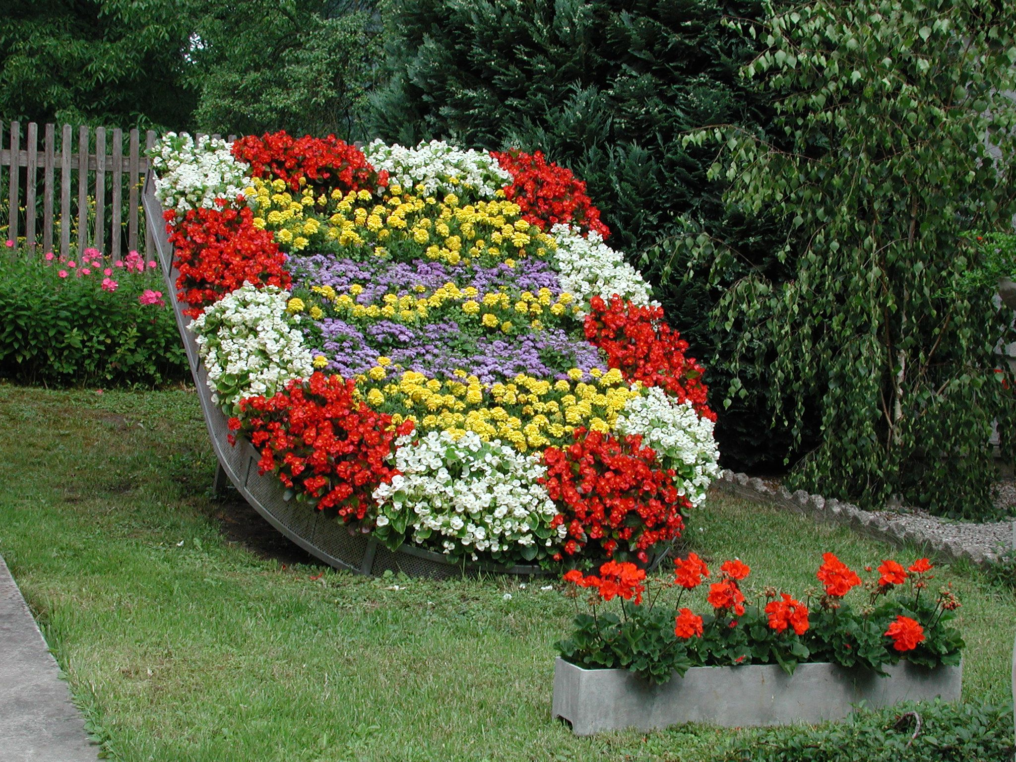 A flower bed in the shape of a coat of arms with colorful flowers.
