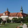 Historic courtyard garden of Seitenstetten Abbey with manicured lawn and baroque architecture in the background.