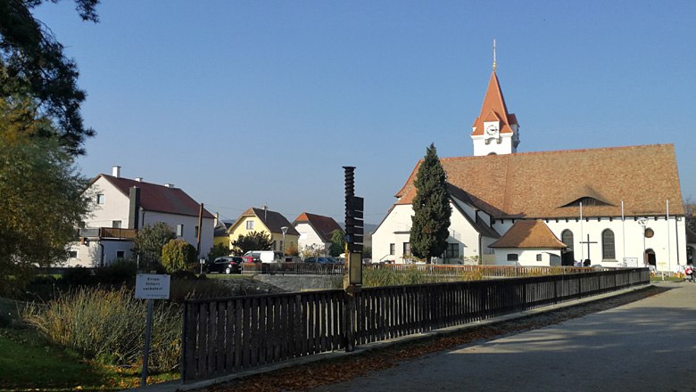 Dro&szlig; parish and pilgrimage church with surrounding buildings and blue sky.