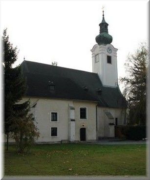 Church with tower and green roof in Schwadorf.