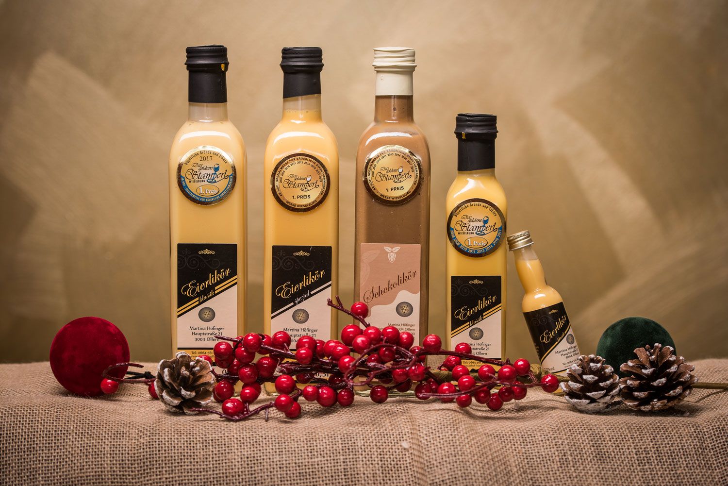 Bottles of egg liqueur and chocolate liqueur on jute with decoration.